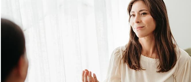 A practitioner in conversation by a window